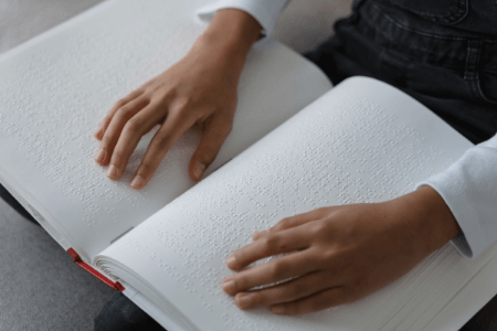 Livre en braille avec des mains qui lisent
