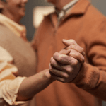 Couple de personnes agés qui danse main dans la main